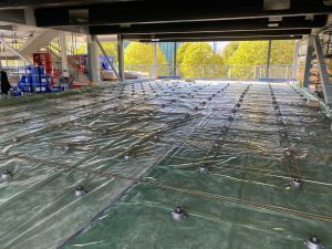 the components of a floating floor laid out before a layer of concrete is poured on top